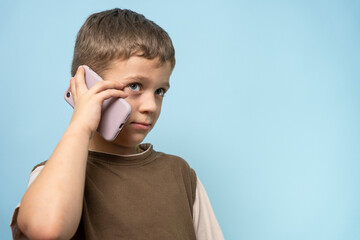naughty caucasian boy talking on the phone . A charming child with a phone