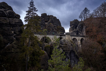 Dark landscape in the Saxon Switzerland with an old bridge