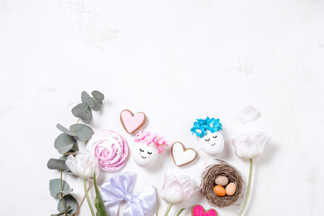 Obraz na płótnie Canvas Stylish eggs with flowers and sweets for Easter. Beautiful banner with space for text for Easter day. Concept of a greeting card flatlay