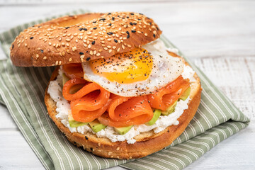 Bagel sandwich with smoked salmon, cream cheese, avocado and egg. - Powered by Adobe