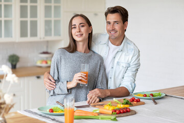 Romantic young couple in love, man and woman hugging and having a great time together in the kitchen at home. Couple life