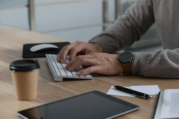 Man working on computer at table in office, closeup