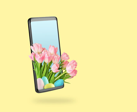 Bouquet of pink tulips and colored Easter eggs that go beyond smartphone screen. Pale yellow background. Creative idea online shopping, delivery and greetings. 3D volumetric photo.