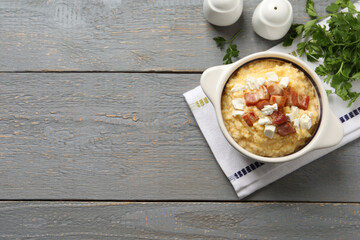 Delicious traditional Ukrainian banosh served on grey wooden table, flat lay. Space for text