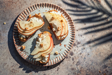 Fototapeta na wymiar bruschetta with pear, goat cheese spread, nuts and honey