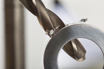 metal drill bit make holes in aluminium pipe on industrial drilling machine. Metal work industry.