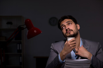 Naklejka premium Young male employee working late in the office