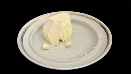 Simple white Plate with Butter. Black background