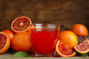 Tasty sicilian orange juice in glass and fruits on wooden table