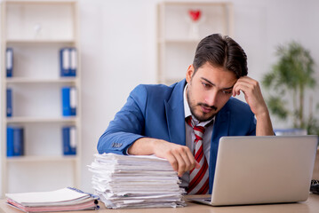 Young male employee and too much work in the office