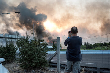 ATHENS, GREECE-03 AUGUST 2021: A man is taking photos/video of the wildfire that raged...
