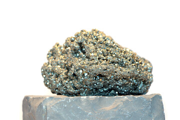 Fools gold, pyrite, on a stone block with white isolated background
