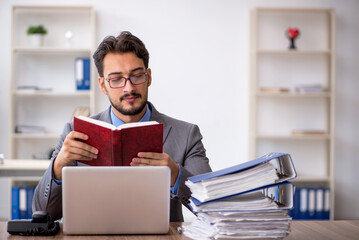 Young male employee unhappy with excessive work in the office