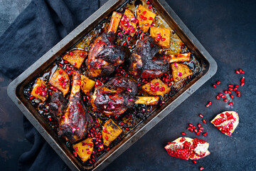 Traditional braised slow cooked Australian lamb shank with pineapple and pomegranate served as top view in a backing form