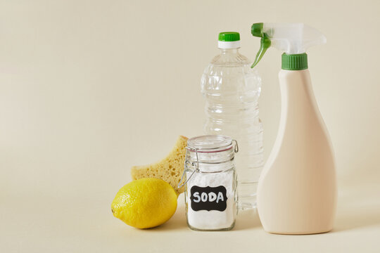 Soda Jar, Spray Bottle, Vinegar, Lemon, Wooden Brush And Sponge On Beige Background Copy Space