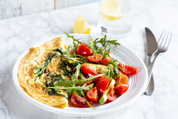 Omelette with arugula and tomatoes salad