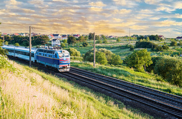 Passenger train with cars while moving on the railway