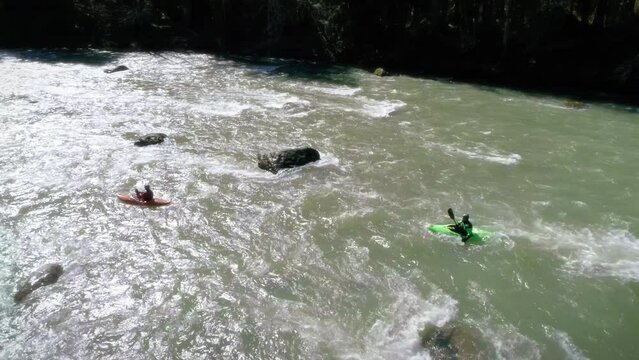 Aerial of Friends Kayaking with Dreamy Sunlight Reflecting Off River Rapids