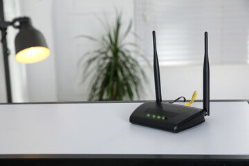Modern Wi-Fi router on table indoors. Space for text - obrazy, fototapety, plakaty