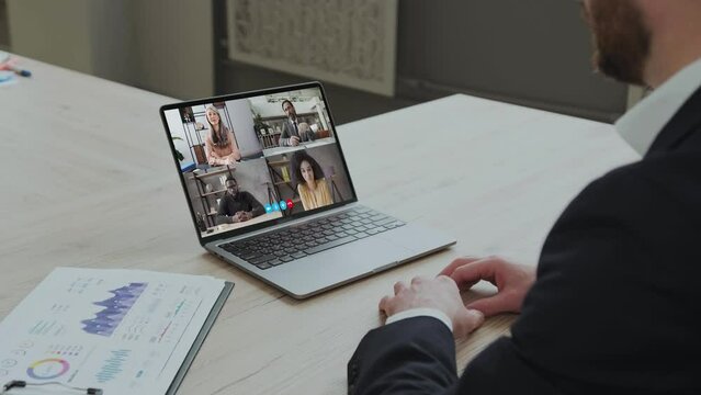 Businessman Having Online Business Meeting With Colleagues Making Video Call on the computer Sitting In Office. Coworkers Communicating Via Video Conference. Distance Work Communication