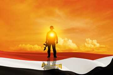 Silhouette of a solider against the sunrise and egyptian flag. Concept - armed forces of Egypt. Egypt celebration. Greeting card for Independence day, Memorial Day, Armed forces day.