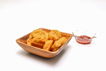 白バックの木製のボウルにのチキンナゲット
