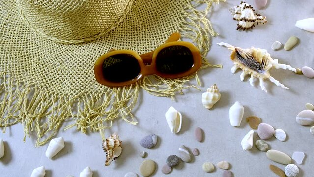 Summertime, vacation, travel and tourism concept - female straw hat and sunglasses lie on beach sand. Travel summer accessories with  copy space, flat lay. Travel planning concept