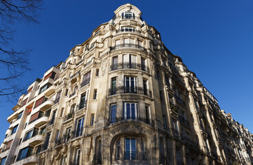 The facade of traditional French house with typical balconies and windows. Paris.