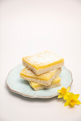 Lemon squares stacked on a plate