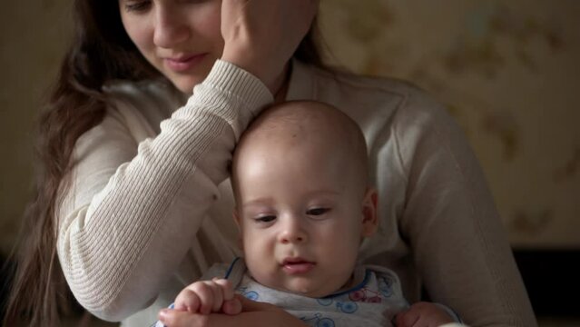Newborn Active Baby With Young Mom. Cute Kid Smiling Teethless Face Portrait Early Days On Stomach Developing Neck Control. Mother And Child Look At Camera Play with Toy. Infant, Beginning Concept
