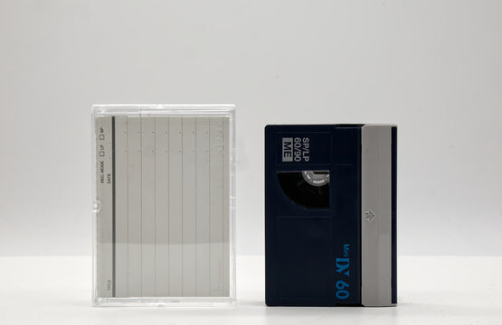 Vintage Mini DV video tape cassette with cassette box on white background. Retro style technology from the 90s