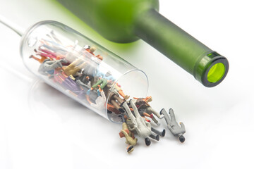 miniature people. alcohol addiction problem concept. alcoholics are in a wine glass against the background of a bottle.