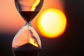 Hourglass on the background of a sunset. The value of time in life. An eternity.