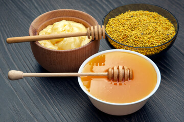 Fresh flower honey of different varieties, pollen and honeycomb with spoons on a wooden background. Organic Vitamin Health Food