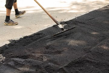 Laying asphalt. Road repairs. Hot asphalt on the road.