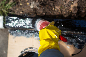 Black paint on a brush and in a bucket.