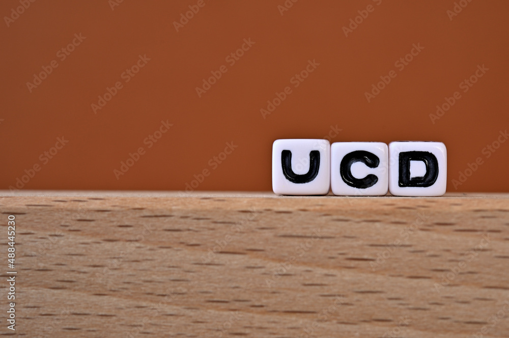 Poster word cubes lined up with the letters ucd written on it. it is an abbreviation for user centered desi