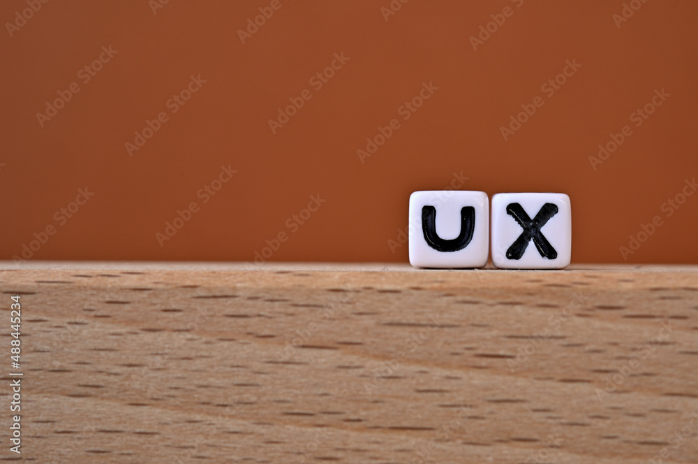 Poster word cubes lined up with the letters ux written on it. it is an abbreviation for user experience. co