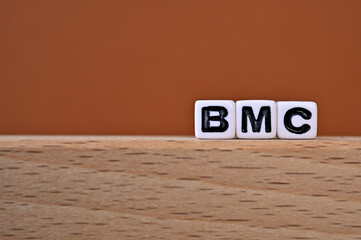 Word cubes lined up with the letters BMC written on it. It is an abbreviation for Business Model...