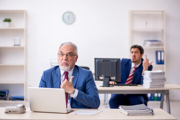 Naklejka na ściany i meble Two male colleagues working in the office