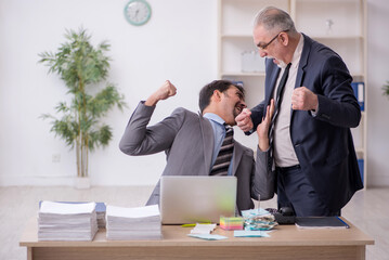 Two male employees in bullying concept