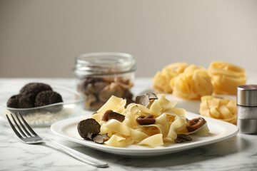 Tasty tagliatelle with truffle on white marble table