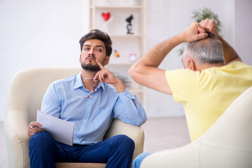 Old man visiting young male psychotherapist