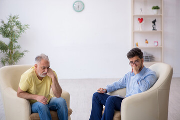 Old man visiting young male psychotherapist