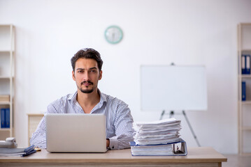 Young male employee and too much work in the office