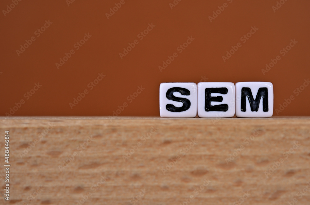 Poster word cubes lined up with the letters sem written on it. it is an abbreviation for search engine mark
