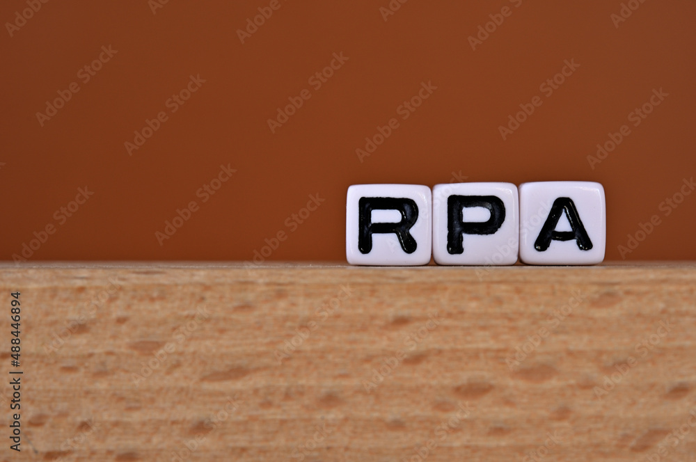 Poster word cubes lined up with the letters rpa written on it. it is an abbreviation for robotic process au