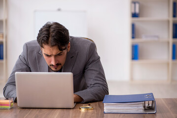 Young male employee sitting in the office