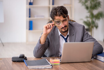 Young male employee sitting in the office