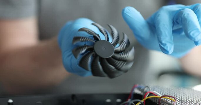 Cooler computer fan in hands of engineer closeup